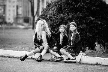 Portrait of a young mother and two beautiful daughters outdoors. Black and white photo.