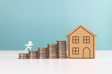 Money saving, real estate investment,mortgage, finance for property, and investing for home lone. Figure of people running step forward on stack of coins with miniature house