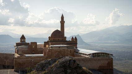 Historical Arabian palace with minarets overlooking city in the valley beneath, Eastern Turkey