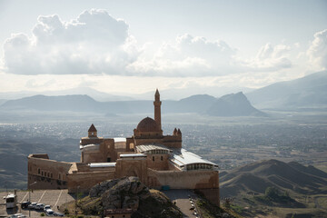 Historical Arabian palace with minarets overlooking city in the valley beneath, Eastern Turkey