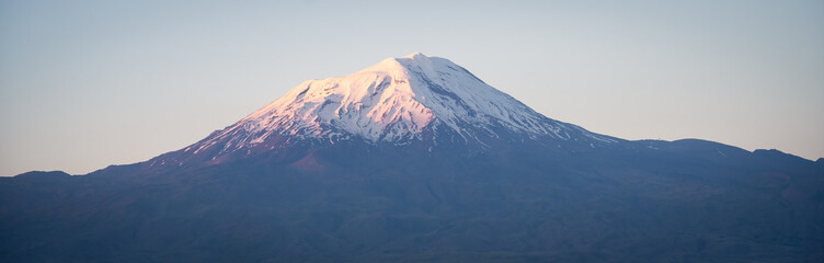 Panoramic shot of massive standalone mountain with snow cap during colorful sunset, Eastern Turkey