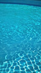 Close view of clear beautiful blue flowing water in swimming pool. Slow motion vertical video. Water surface. Travel and vacation concept. Summer