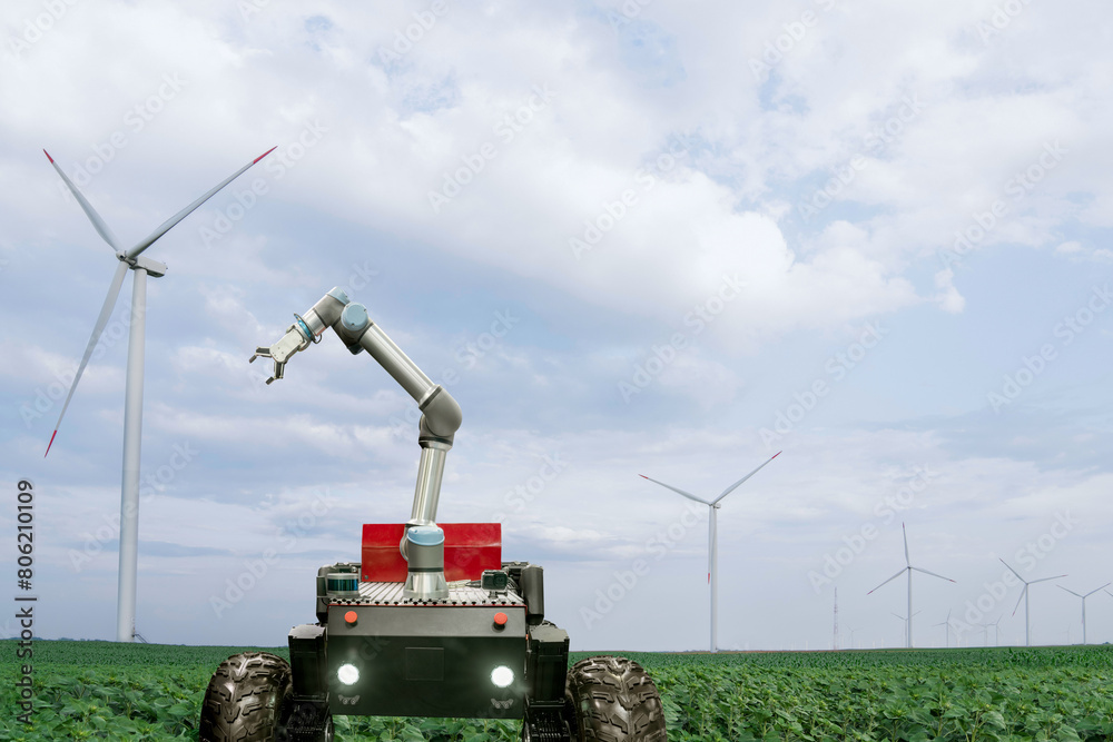Aufkleber Autonomous robot harvester with robotic arm is working on a field with wind turbines.