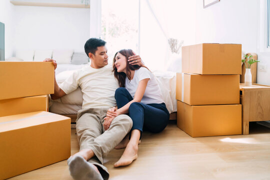 husband hugging sleepy wife lifting box up to bedroom. man worn out from lifting packaging up floor wife lean sitting near bed. exhausted woman fatigued from lifting too many box packaging up stairs