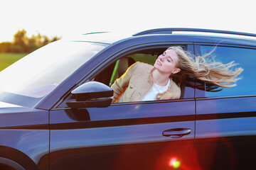 girl looks out the car window and the wind blows her hair