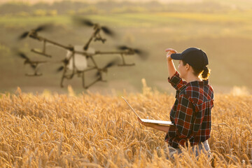 Woman farmer controls drone sprayer with a tablet. Smart farming and precision agriculture..