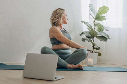 A 50-year-old woman does online yoga at home