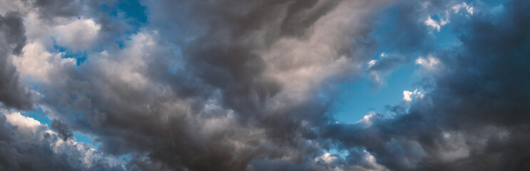 Moody dark clouds on stormy sky panorama, natural horizontal background