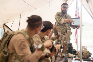 Soldiers have an operation plan meeting in a tent before the mission