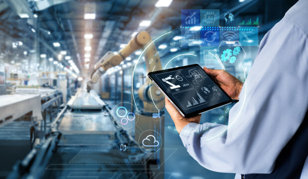Smart industry control concept.Hands holding tablet on blurred automation machine as background