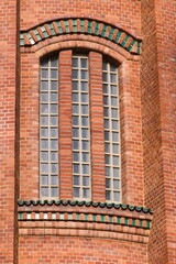 Vintage tower building made of orange bricks. Lovey plastic texture facing on the building. 