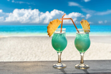 two blue cocktails with ananas slices at the beach