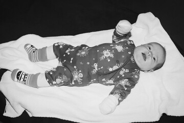 Baby in Floral Onesie on White Blanket