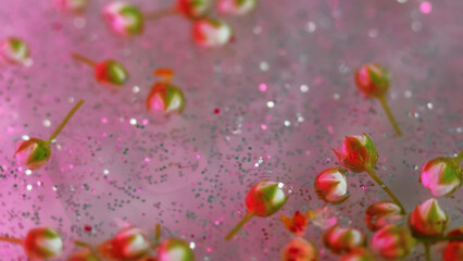 Glowing flowers. Shimmer paint. Defocused pink green silver color shine rose buds floating in...