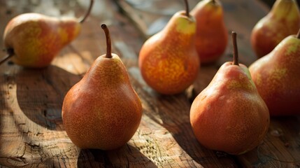 Photo of fresh, ripe pears on a rustic wooden surface bathed in natural light, perfect for culinary and agricultural themes.