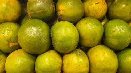 Close up pile of tasty fresh oranges sold at the market as a background.