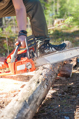 Man working in forest and holding chain saw in motion