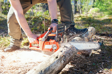 Man working in forest and holding chain saw in motion