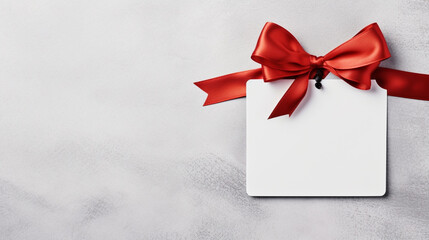 Blank white empty price tag, white note or gift card mock up with red gift ribbon bow on grey wall background with shadow, Merry Christmas and New Year decoration, generative AI