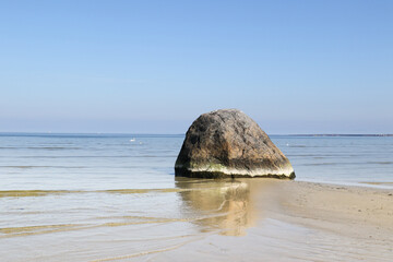 Rock boulder and sand in shallow water on beach in Tallin, Estonia