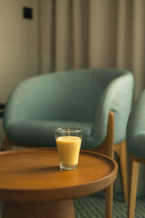 Interior of living room with coffee table with fresh juice. Fresh blended peach smoothie