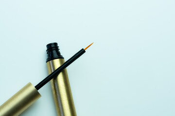 Composition of an open eyeliner on a neutral white background