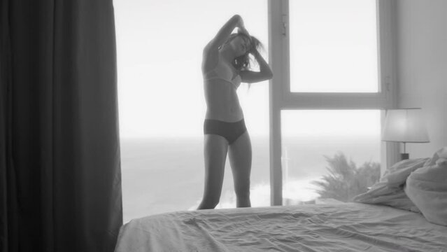 Woman in underwear stands in hotel and flips hair aggressively
