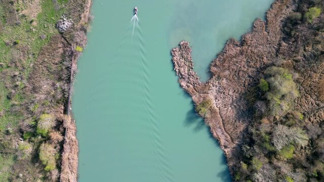 flying over a turquoise river, top view, a boat floats along the river