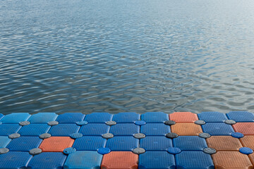 Floating pier made of composite plastic blocks on the river, sea. Plastic bridge on a lake