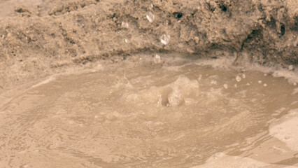 Small children playing with beach sand and waves