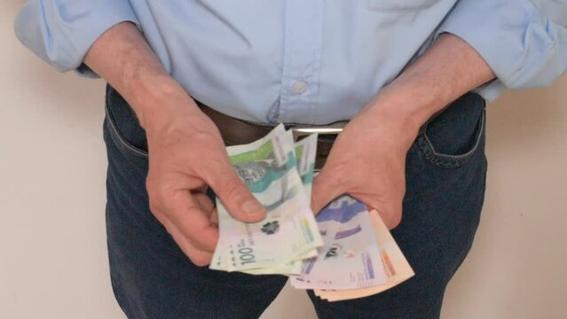 Hombre contando Dinero Colombiano divisa
