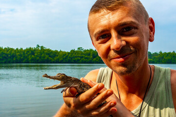 Man tourist with baby crocodile alligator Sri Lanka.