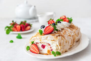 Meringue pavlova roll with mascarpone cream, fresh  strawberries and blueberries