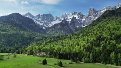 Aerial view of green pasture and breathtaking peaks of Triglav mountain. Julian Alps, Triglav National Park, Slovenia, 4k