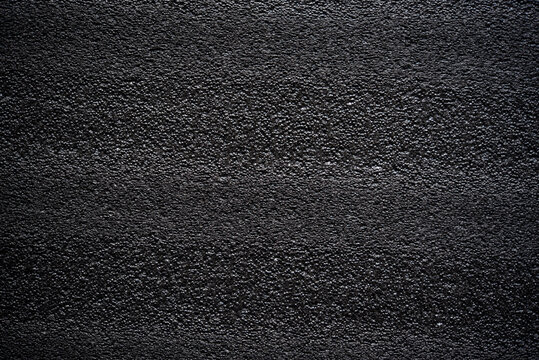 Black porous porous foam background. Background texture of black foam rubber