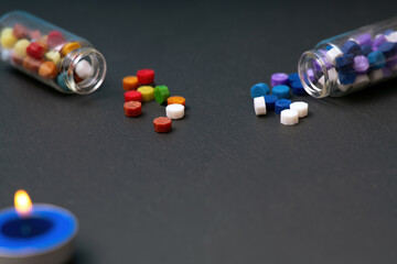 Glass bottles with hexagonal multicolored wax seals on a dark background