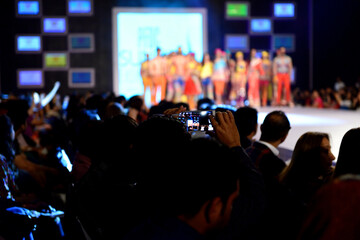 A man from the crowd taking pictures of models from his cell phone during the PFDC fashion week...