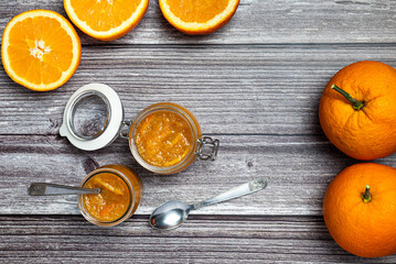 Tasty and healthy homemade orange marmalade. Top view of a table with a jar of homemade orange...