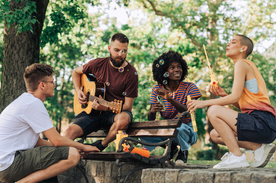 Multicultural traveling musicians having jam session in city park.
