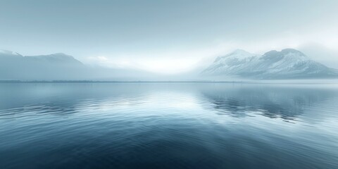 Tranquil mountain lake landscape with snow capped mountains in the distance