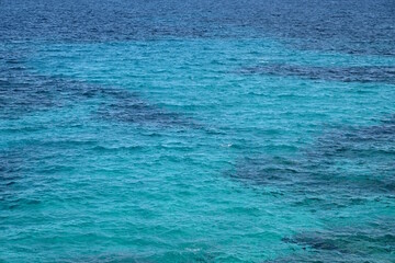 Türkisblaues Wasser am Mittelmeer mit Sand und Korallen Querformat