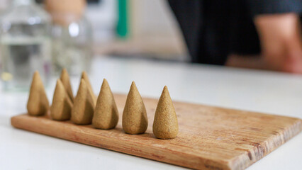Close view of incense cones on a wooden board.