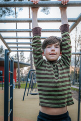 Obraz premium boy was hanging upside down on the bars. Smiling happy child