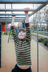 Fototapeta premium boy was hanging upside down on the bars. Smiling happy child