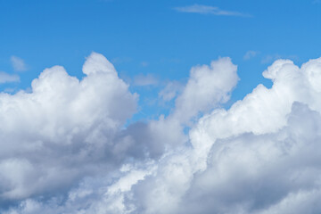 Electric blue sky with fluffy cumulus clouds creating a picturesque landscape