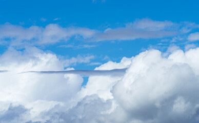 Electric blue sky with fluffy cumulus clouds creating a picturesque landscape