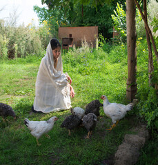 Girl feeding chickens in the garden