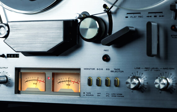 Arrow indicators of the recording level on a reel-to-reel tape recorder. Stereo VU meter background.