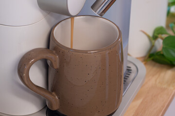 A brown ceramic mug filled with a caffeine beverage.