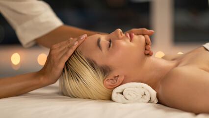 Obraz premium The photo shows a blonde woman lying down during a facial massage at a spa, with a calm and peaceful expression, enhancing her youthful glow